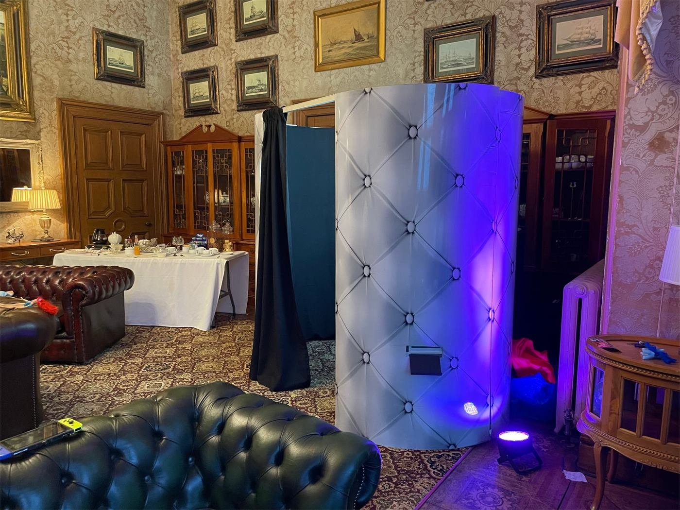 Enclosed photo booth with uplighting at a wedding venue